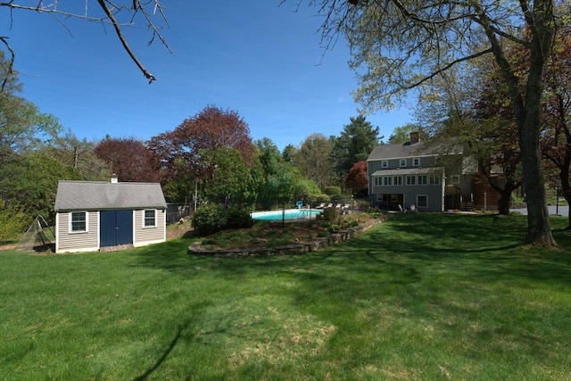 view of yard featuring an outdoor structure and an outdoor pool