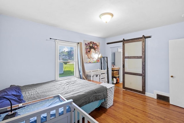 206 Pleasant St, North Andover, MA 01845 - bedroom with light wood-style flooring, a barn door, and access to exterior