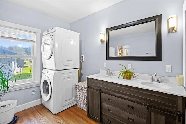 206 Pleasant St, North Andover, MA 01845 - bathroom featuring stacked washing machine and dryer, wood finished floors, baseboards, and double vanity