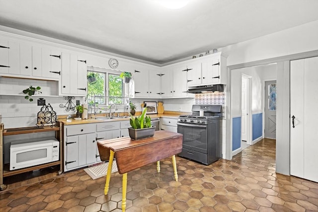 206 Pleasant St, North Andover, MA 01845 - kitchen with gas stove, white microwave, under cabinet range hood, light countertops, and tasteful backsplash