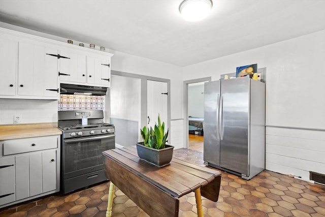 206 Pleasant St, North Andover, MA 01845 - kitchen featuring appliances with stainless steel finishes, under cabinet range hood, light countertops, decorative backsplash, and white cabinetry