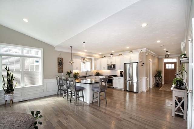 29 Spyglass Ln, Plymouth, MA 02360 - kitchen featuring stainless steel appliances, dark countertops, a kitchen bar, a decorative wall, and a sink