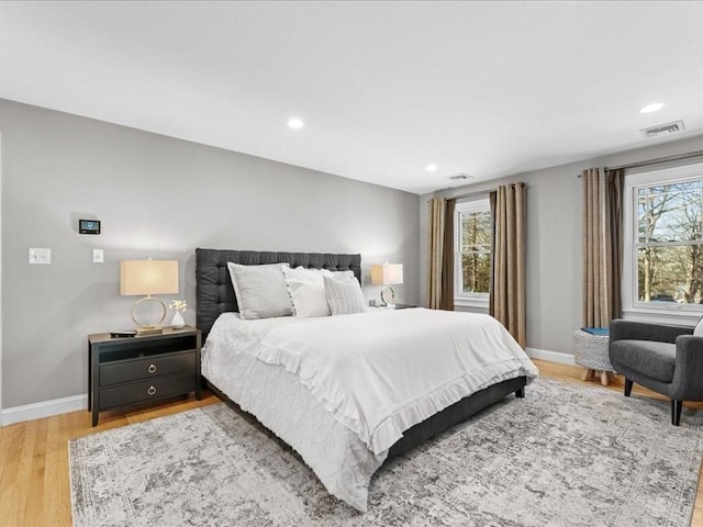 bedroom featuring multiple windows and light hardwood / wood-style flooring