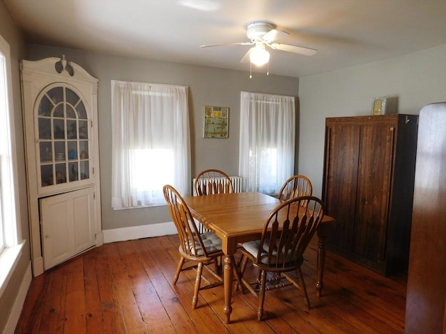 dining space with baseboards, a ceiling fan, and hardwood / wood-style floors