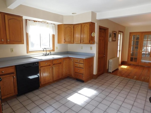 kitchen with radiator, dishwasher, light countertops, brown cabinets, and a sink