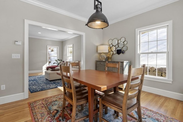 dining room with light wood-style floors, baseboards, and ornamental molding