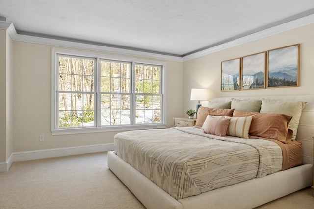 carpeted bedroom with ornamental molding and baseboards