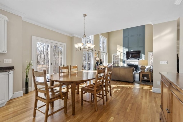 dining room with light wood-style floors, baseboards, and ornamental molding