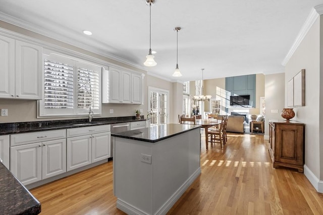 kitchen featuring light wood finished floors, a kitchen island, and white cabinets