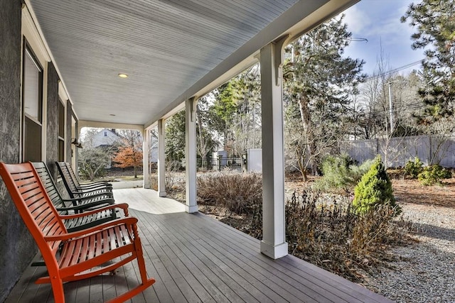 deck featuring covered porch and fence