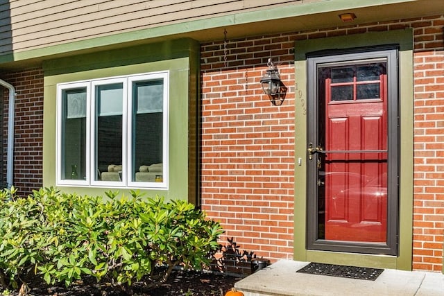 view of exterior entry with brick siding