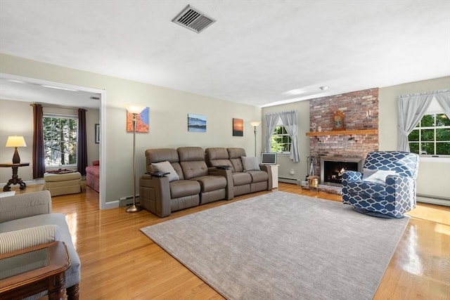 1 Burnham Ln, Danvers, MA 01923 - living area with plenty of natural light, light wood-style flooring, a brick fireplace, and a baseboard radiator