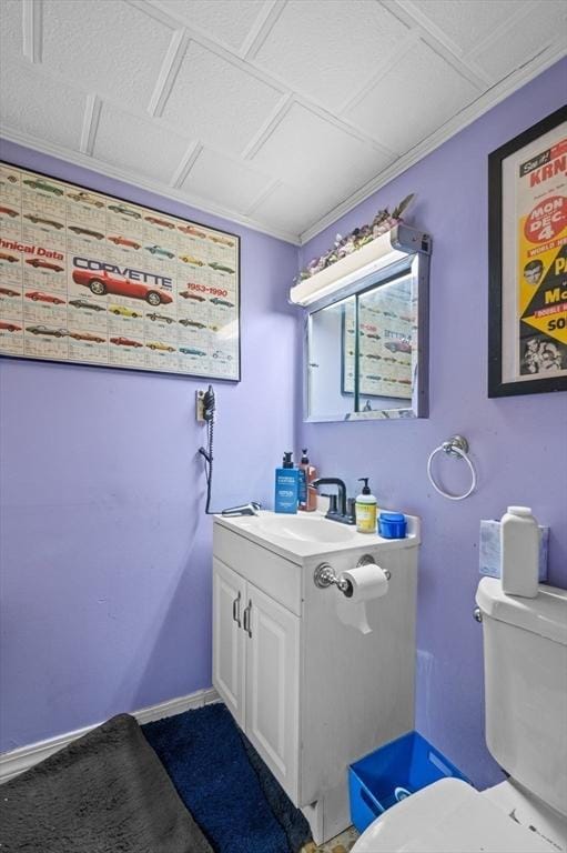 bathroom with vanity, toilet, and baseboards