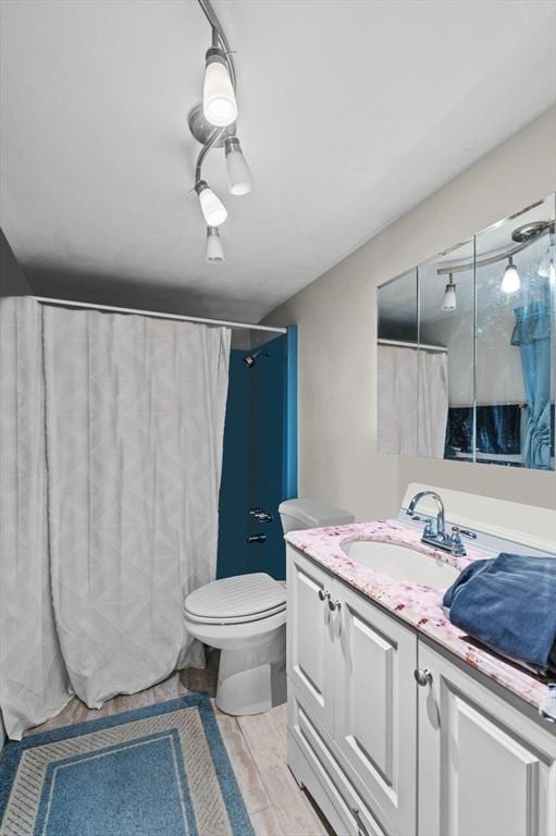 bathroom with toilet, vanity, and a shower with curtain