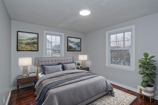 bedroom with dark hardwood / wood-style flooring and multiple windows