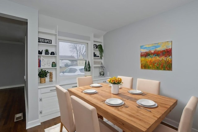 dining area featuring dark hardwood / wood-style flooring and built in features