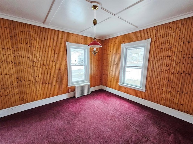 spare room featuring radiator heating unit, plenty of natural light, dark colored carpet, and crown molding