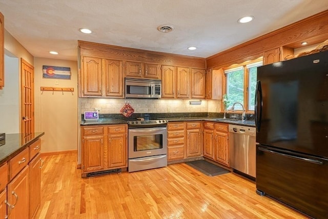 113 Edgehill Rd Unit 113, Norwood, MA 02062 - kitchen with appliances with stainless steel finishes, light wood-style flooring, backsplash, brown cabinetry, and recessed lighting