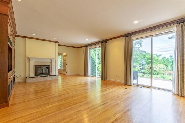 109 Wild Grove Ln, Longmeadow, MA 01106 - unfurnished living room featuring crown molding, light wood-type flooring, a tiled fireplace, baseboards, and recessed lighting