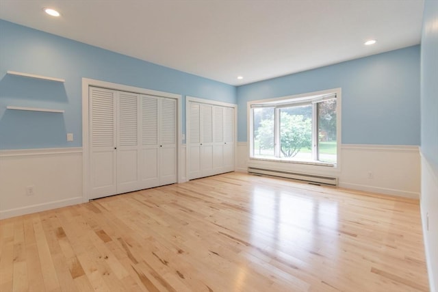 109 Wild Grove Ln, Longmeadow, MA 01106 - unfurnished bedroom with a baseboard heating unit, wood finished floors, two closets, a wainscoted wall, and recessed lighting