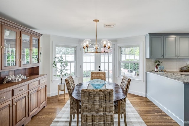 dining room with a chandelier, wood finished floors, and baseboards