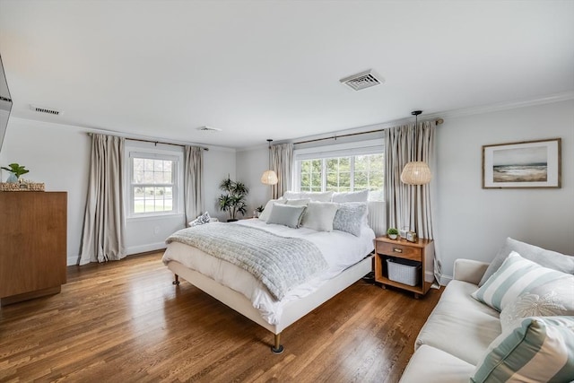 bedroom with ornamental molding, wood finished floors, and baseboards