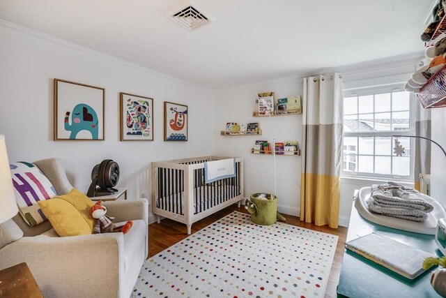 bedroom featuring ornamental molding, wood finished floors, and baseboards
