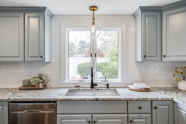 kitchen with gray cabinets, a sink, backsplash, and plenty of natural light