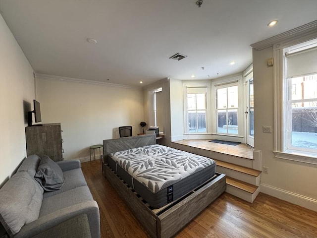 bedroom featuring hardwood / wood-style floors and crown molding