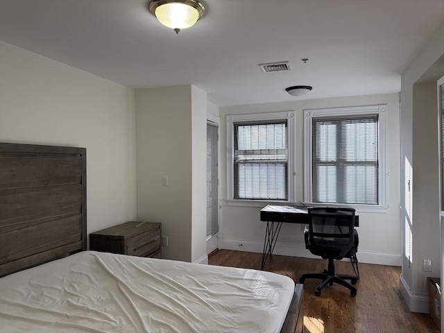 bedroom with dark hardwood / wood-style floors