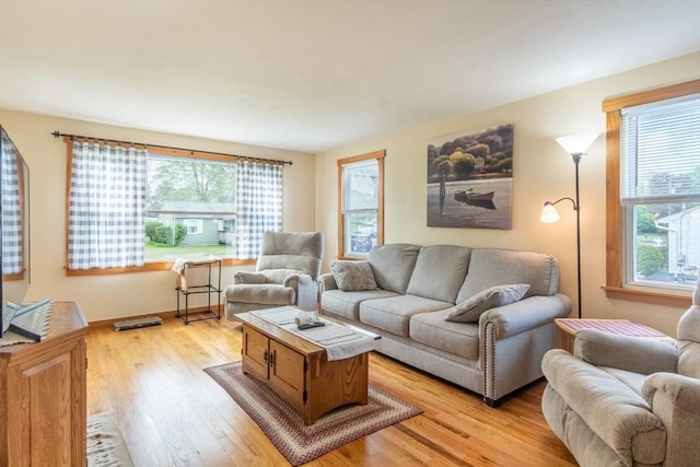 living area featuring plenty of natural light, light wood-style floors, and baseboards
