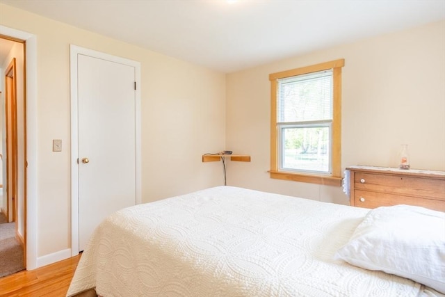 bedroom with light wood finished floors and baseboards