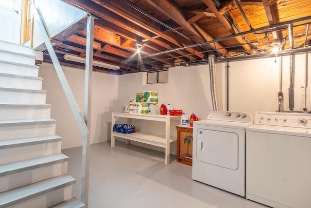 unfinished below grade area featuring washing machine and clothes dryer and stairway