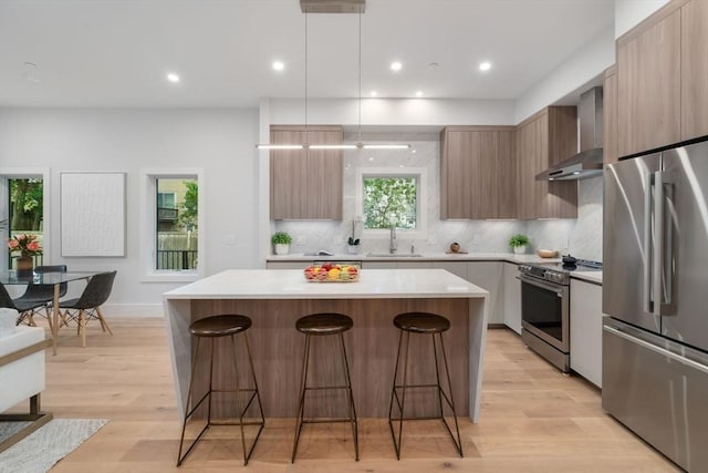 2202 Commonwealth Ave Unit 3, Newton, MA 02466 - kitchen featuring stainless steel appliances, wall chimney exhaust hood, modern cabinets, a kitchen island, and recessed lighting