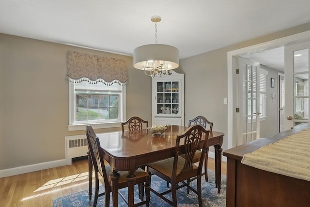 dining area with plenty of natural light, baseboards, wood finished floors, and a chandelier