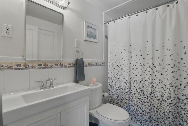 full bathroom featuring vanity, curtained shower, toilet, tile walls, and a wainscoted wall