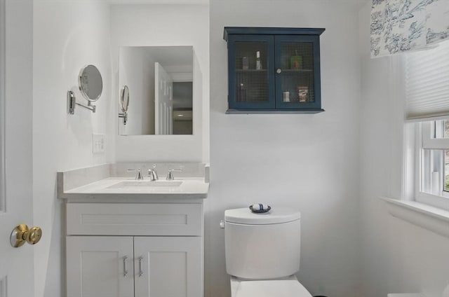 half bathroom with vanity and toilet