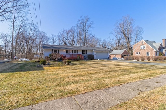 view of front of home featuring driveway, a front lawn, covered porch, a garage, and a chimney