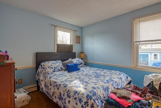 bedroom with a textured ceiling, dark wood-type flooring, and a baseboard radiator