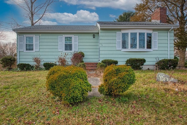 single story home featuring a front lawn