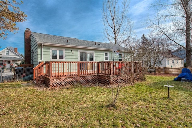 rear view of property with a lawn and a wooden deck