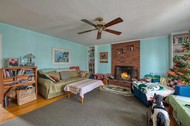 living room featuring ceiling fan, carpet floors, a textured ceiling, and a brick fireplace