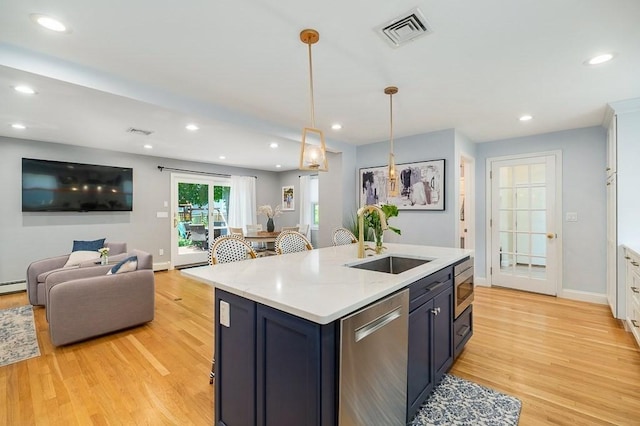 31 Orchard Rd, Hamilton, MA 01982 - kitchen featuring appliances with stainless steel finishes, light wood-style floors, light countertops, an island with sink, and recessed lighting