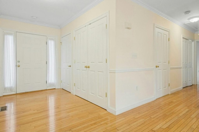 foyer entrance featuring ornamental molding and light hardwood / wood-style floors