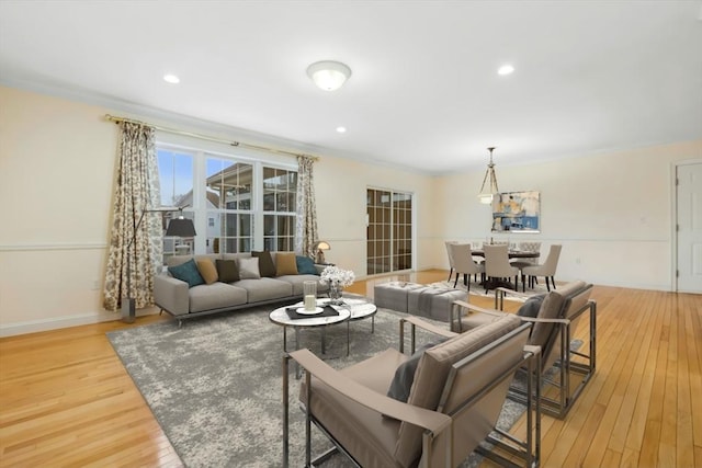 living room featuring ornamental molding and light hardwood / wood-style flooring