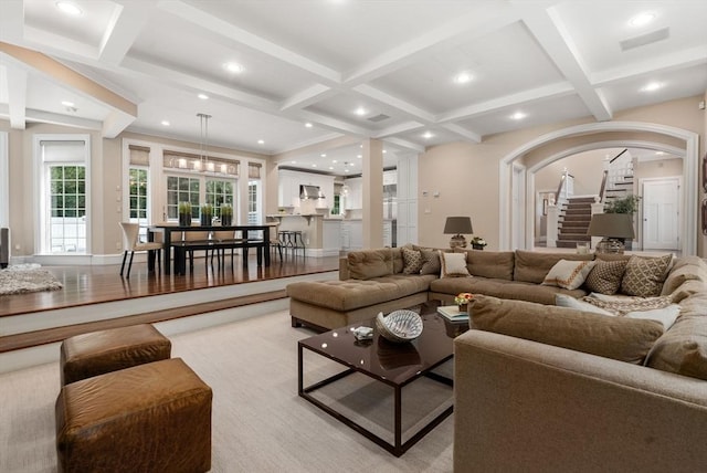 living room with coffered ceiling, stairway, beam ceiling, arched walkways, and recessed lighting