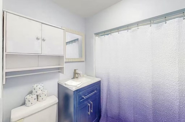 bathroom with vanity, toilet, and curtained shower