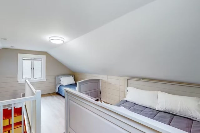 bedroom featuring lofted ceiling and light wood-type flooring