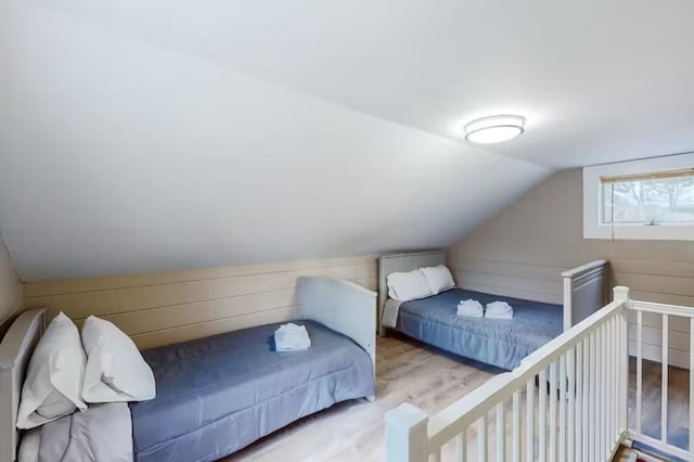 bedroom with lofted ceiling and light wood-type flooring