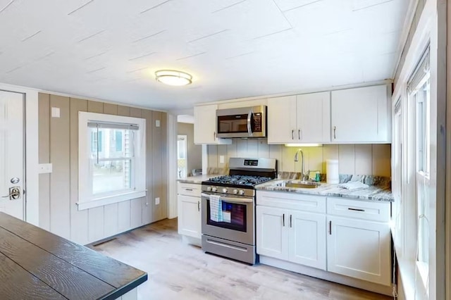 kitchen featuring sink, white cabinets, light hardwood / wood-style flooring, and stainless steel appliances